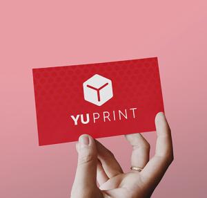 Tarjeta de presentación de Yuprint sostenida con la mano, diseño corporativo rojo con logotipo impreso.