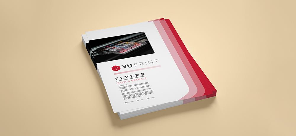 Flyers Yuprint apilados con diseño corporativo rojo, ideales para impresión publicitaria y promoción empresarial.