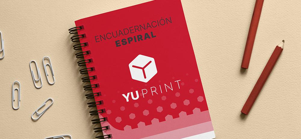 Cuaderno YUPrint con encuadernación espiral y diseño rojo corporativo sobre escritorio, impresión profesional