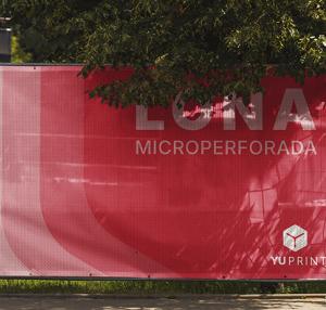Lonas microperforadas YuPrint instaladas en vallas, ideales para obras y eventos con gran visibilidad.