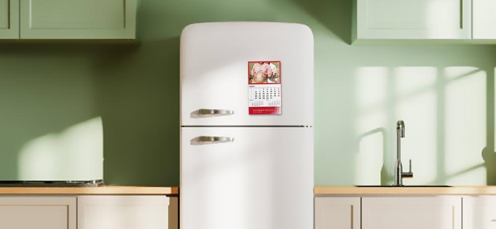 Calendario faldilla con imán personalizado adherido a nevera blanca en cocina moderna