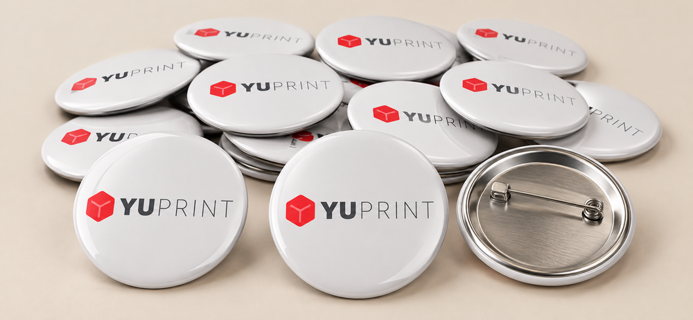 Lote de chapas blancas personalizadas con logo de Yuprint y una chapa con el alfiler trasero visible